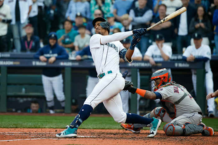 Seattle Mariners center fielder Julio Rodriguez swings with a Houston Astros catcher behind him